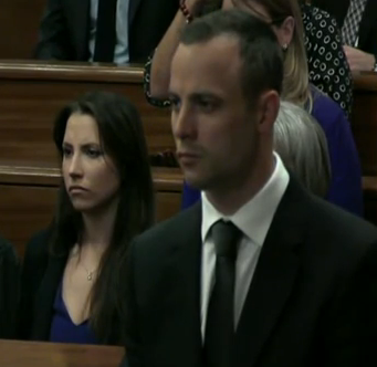Oscar Pistorius in court today (with his sister in the background)