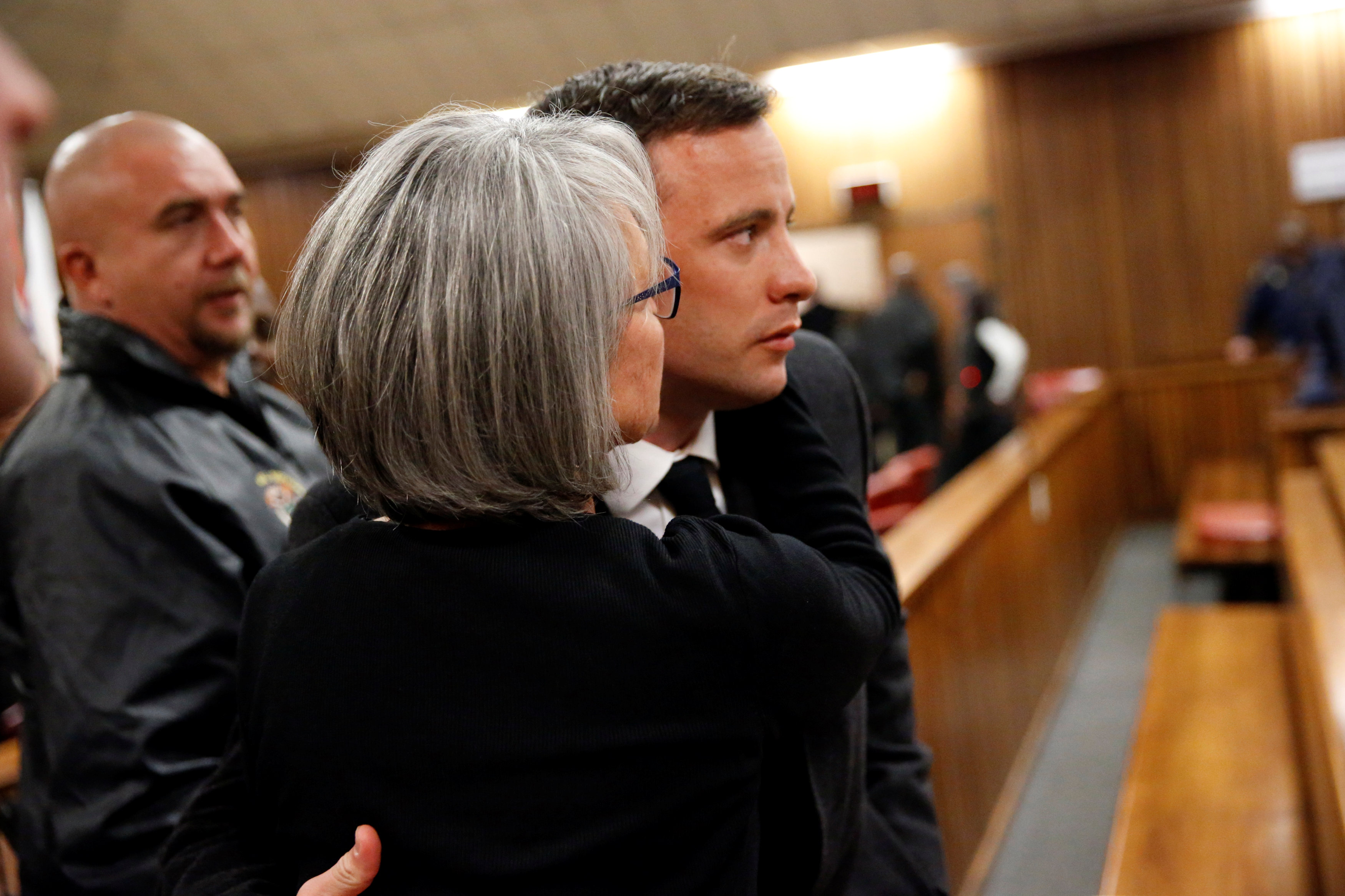 Olympic and Paralympic track star Oscar Pistorius reacts with a family member at his sentence hearing at the North Gauteng High Court in Pretoria, South Africa, July 6, 2016. REUTERS/Marco Longari/Pool