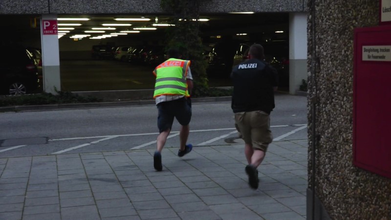A screen grab taken from video footage shows plain clothes police officers running towards car park of the Olympia shopping mall during shooting rampage in Munich, Germany July 22, 2016. dedinac/Marc Mueller/ handout via REUTERS
