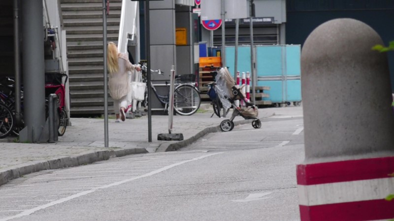 A screen grab taken from video footage shows a woman leaving the Olympia shopping mall during a shooting rampage in Munich, Germany July 22, 2016. dedinac/Marc Mueller/ handout via REUTERS