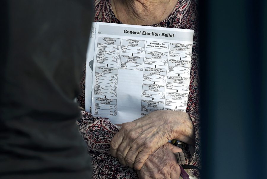 A woman carries her sample ballot before she casts her ballot during voting in the 2016 presidential election at Desert Pines High School in Las Vegas, Nevada, U.S November 8, 2016. REUTERS/David Becker
