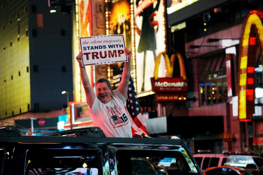 A man leans out of a Hummer shouting words in support of U.S. Republican presidential nominee Donald Trump while driving through Times Square in New York, U.S., November 9, 2016. REUTERS/Mark Kauzlarich