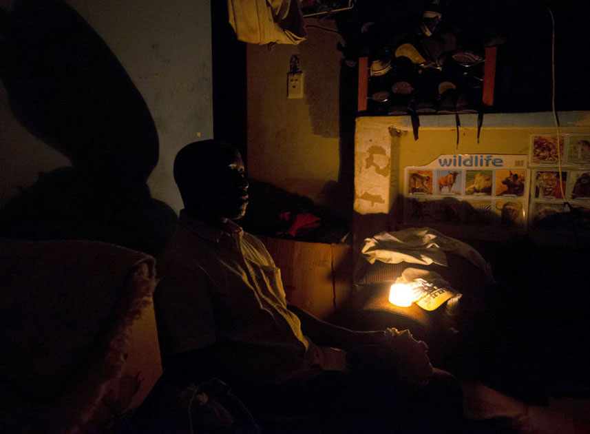 A man uses candle light during load shedding in Embo
