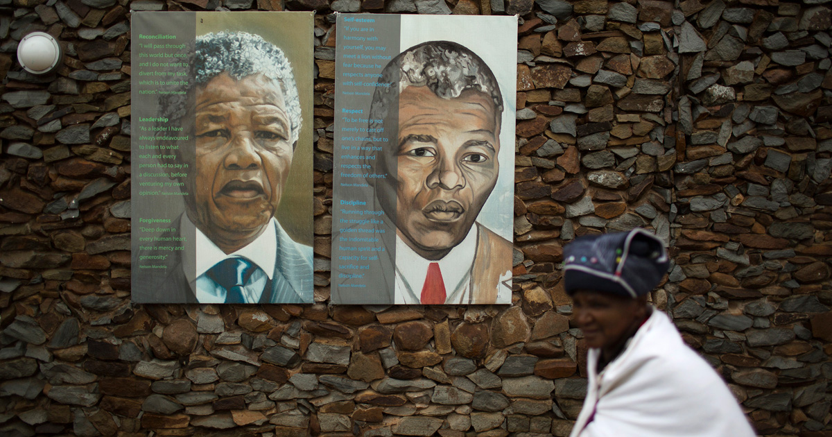 A woman walks past portraits of former South African President Nelson Mandela at the end of a memorial service in the Nelson Mandela Museum in Qunu December 10, 2013. REUTERS/Siegfried Modola/File Photo