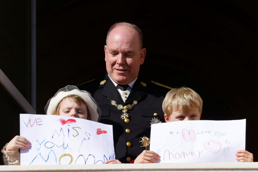 Prince Albert II of Monaco, Prince Jacques and Princess Gabriella holding message which read "We miss you mommy" and "We love you mommy", stand on the palace balcony during the celebrations marking Monaco's National Day in Monaco, November 19, 2021. REUTERS/Eric Gaillard