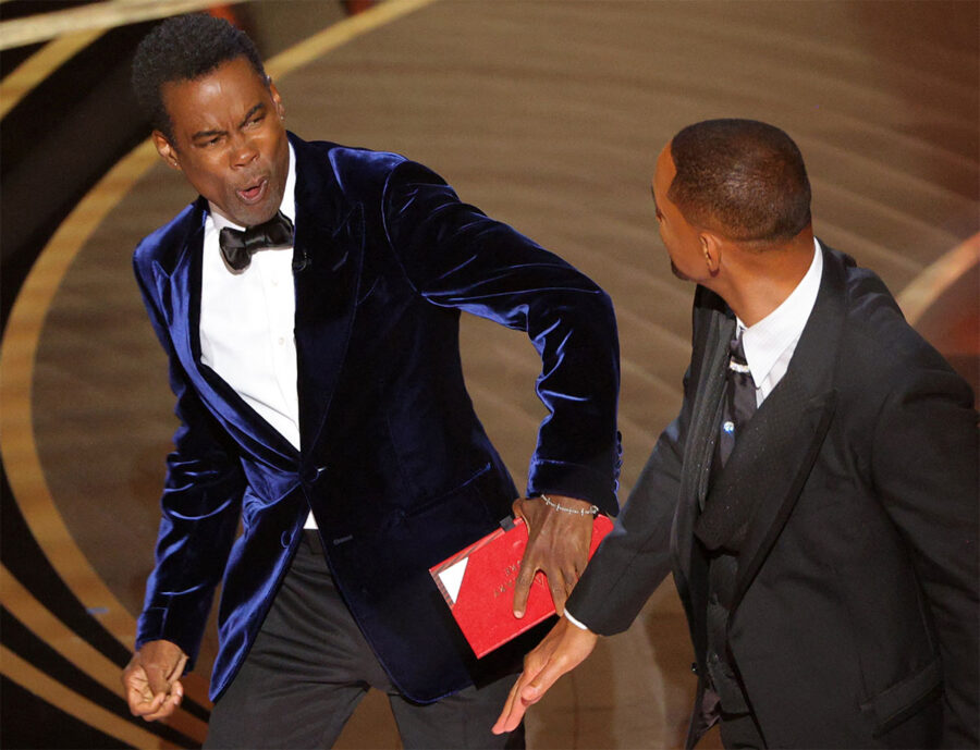 Will Smith (R) hits at Chris Rock as Rock spoke on stage during the 94th Academy Awards in Hollywood, Los Angeles, California, U.S., March 27, 2022. REUTERS/Brian Snyder