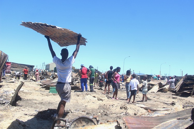 192 people were left homeless when 81 structures were destroyed in a fire in Town Two, Khayelitsha in Cape Town on Saturday morning. On Sunday, some people had begun rebuilding their homes. Photo: Masixole Feni