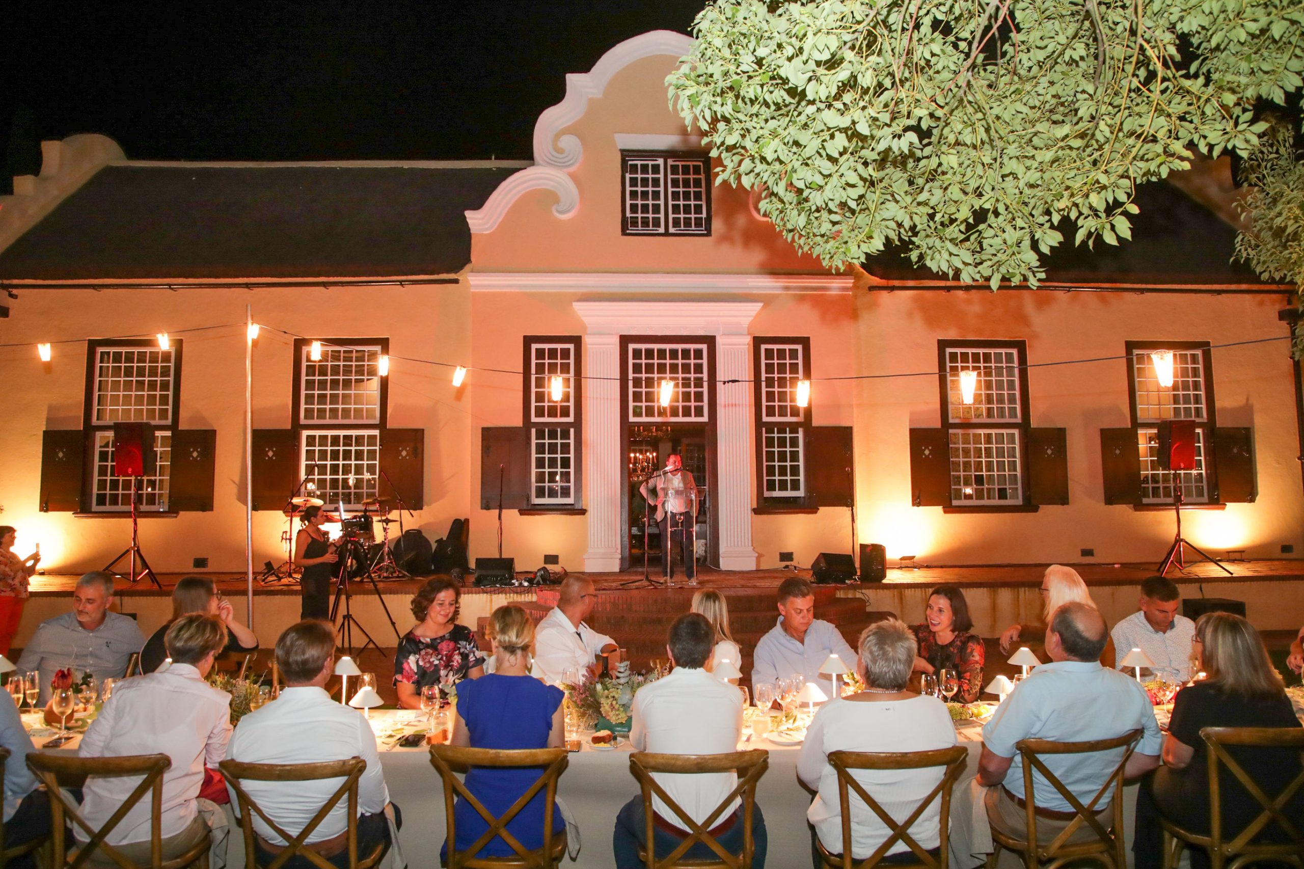 Wine lovers are entertained at a long table in front of Vergelegen’s historic homestead. Photo: A Gorman Photography