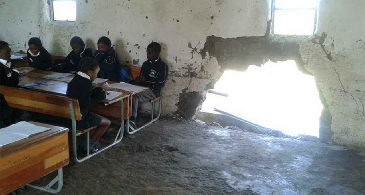 Mud classrooms crumble while building materials sit on site