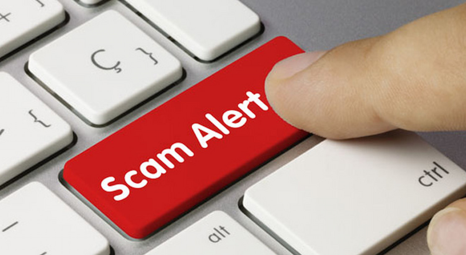 Stock image of a "scam alert" key on a keyboard, being pressed by a finger. forex scammers south africa