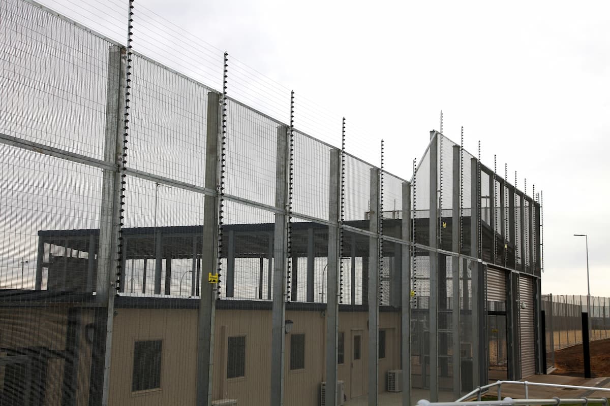 Image of fence at Yongah Hill Immigration Detention Centre. This photo accompanies an article about a so-called Afrikaner refugee, Benjamin Schoonwinkel, who was detained in the United States by ICE