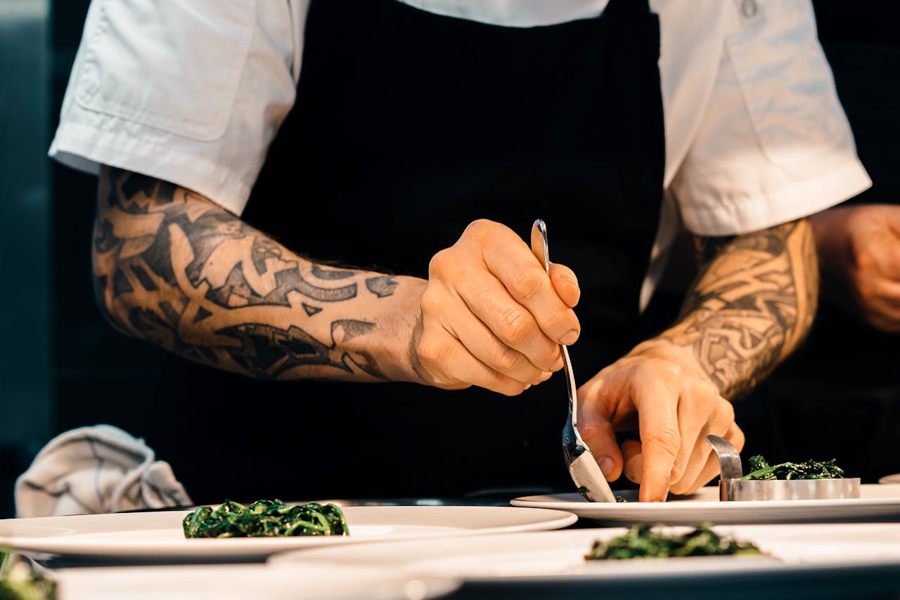 Image of a chef plating food. Image accompanies article about Cape Town restaurants and their perceived snubbing by Michelin